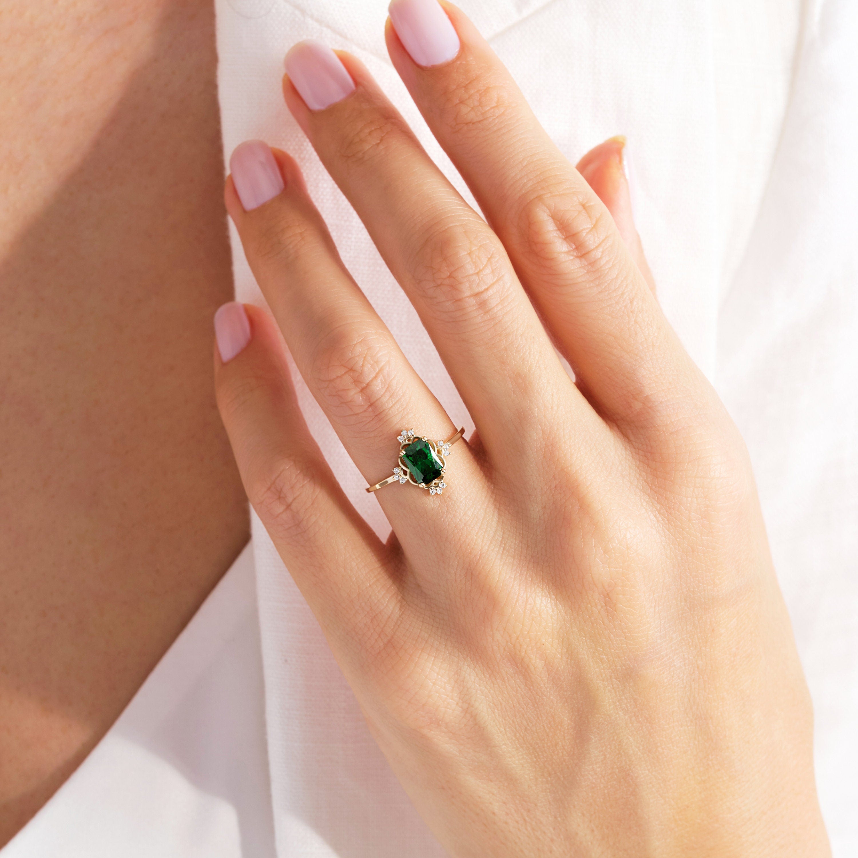 Emerald Cut Emerald Wedding Ring – 14K Solid Gold Band with Side Diamonds 💚✨
This Emerald Cut Wedding Ring celebrates timeless beauty and craftsmanship. Featuring a stunning 7x5 mm natural emerald surrounded by sparkling side diamonds, it radiates sophistication and meaning. The rectangular emerald symbolizes renewal and growth — a perfect piece for weddings, anniversaries, or milestone celebrations.