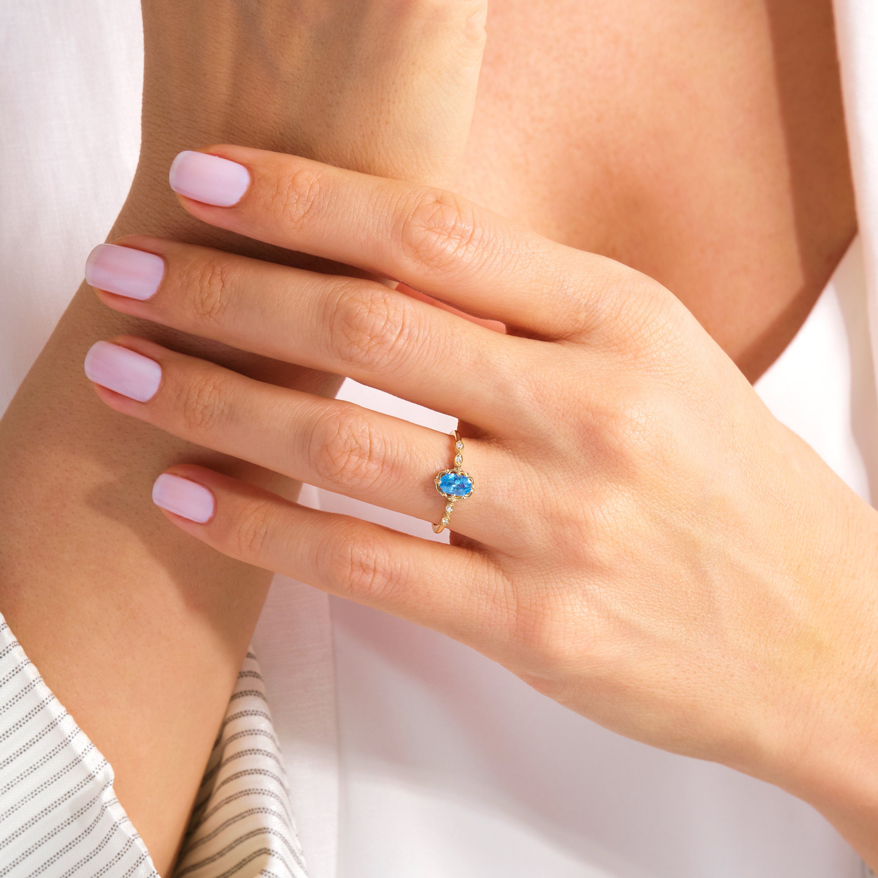 Oval Blue Topaz Engagement Ring – 14K Solid Gold Lace Band 💙✨
Delicate, radiant, and full of charm — this Oval Blue Topaz Engagement Ring brings a touch of the sky to your hand. Expertly crafted in solid 14K gold, it features a 6x4 mm oval-cut blue topaz, symbolizing peace and loyalty, surrounded by sparkling moissanites or diamonds on a graceful lace-inspired band.