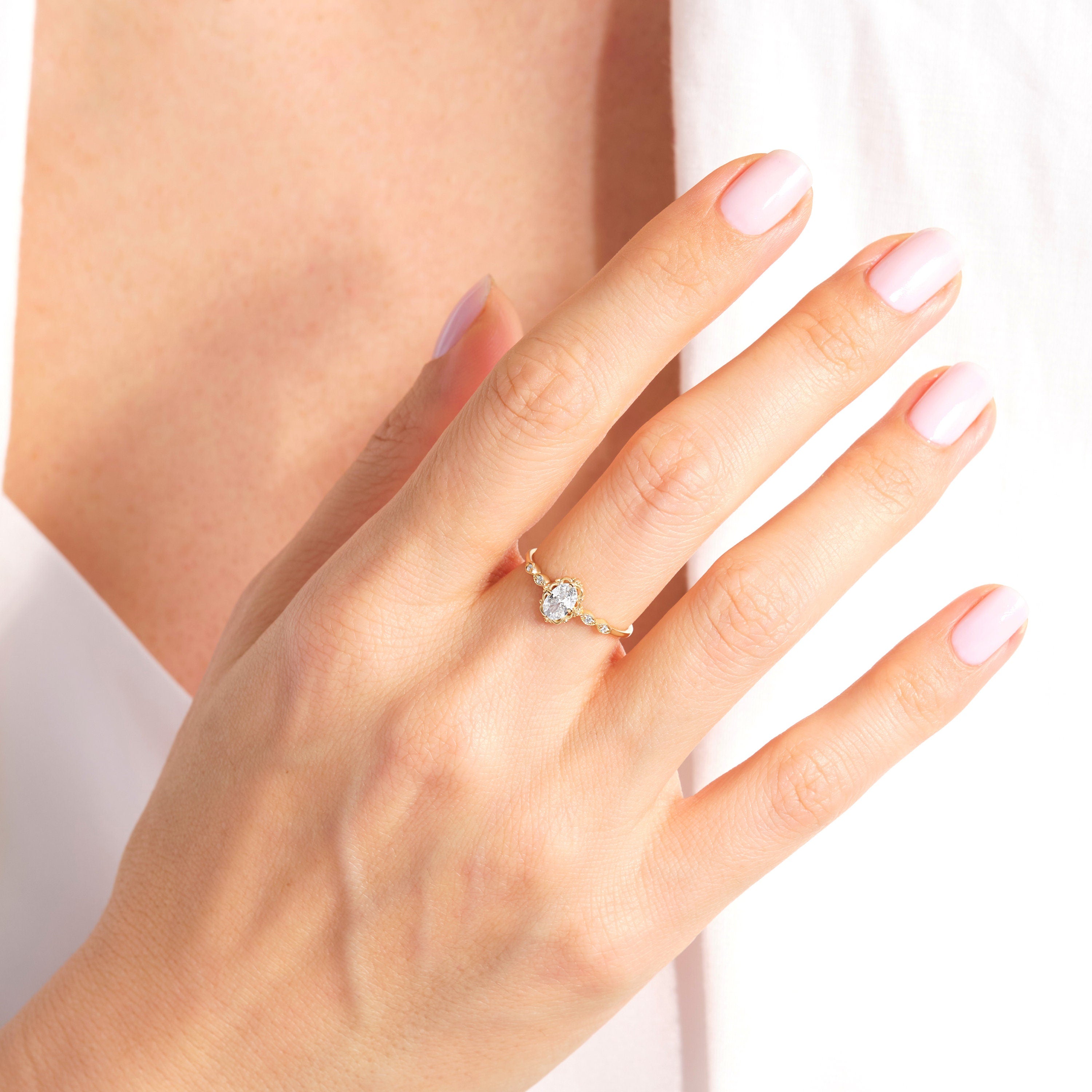 đ Oval Diamond Engagement Ring â 14K Solid Gold Moissanite Wedding Band
This elegant oval engagement ring features a sparkling center stone paired with a delicate row of tiny accent gems. Its slim solid-gold band and refined silhouette make it perfect as a proposal ring, wedding band, promise ring, or everyday luxury piece. A timeless design for women who love delicate, feminine fine jewelry.