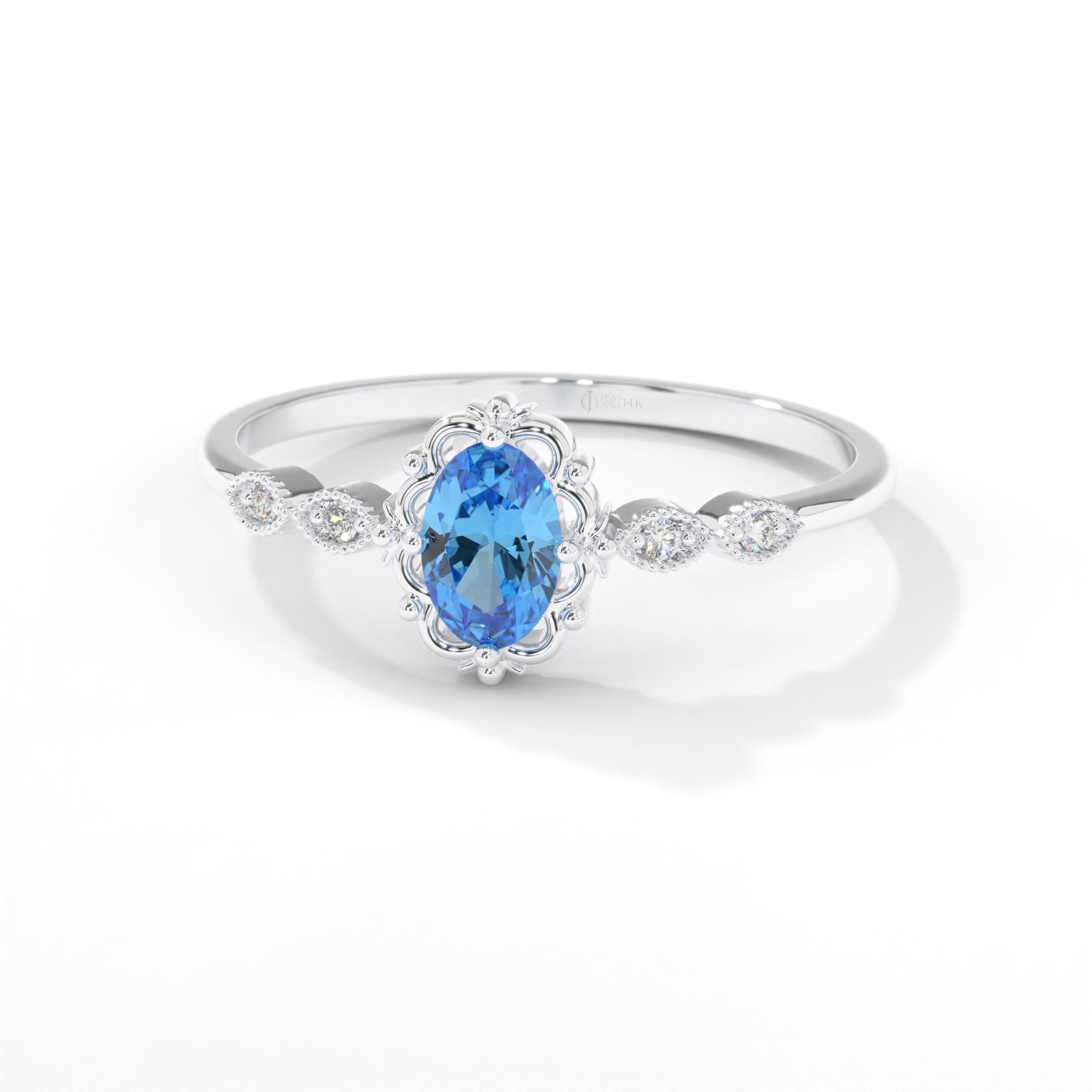 Oval Blue Topaz Engagement Ring – 14K Solid Gold Lace Band 💙✨
Delicate, radiant, and full of charm — this Oval Blue Topaz Engagement Ring brings a touch of the sky to your hand. Expertly crafted in solid 14K gold, it features a 6x4 mm oval-cut blue topaz, symbolizing peace and loyalty, surrounded by sparkling moissanites or diamonds on a graceful lace-inspired band.