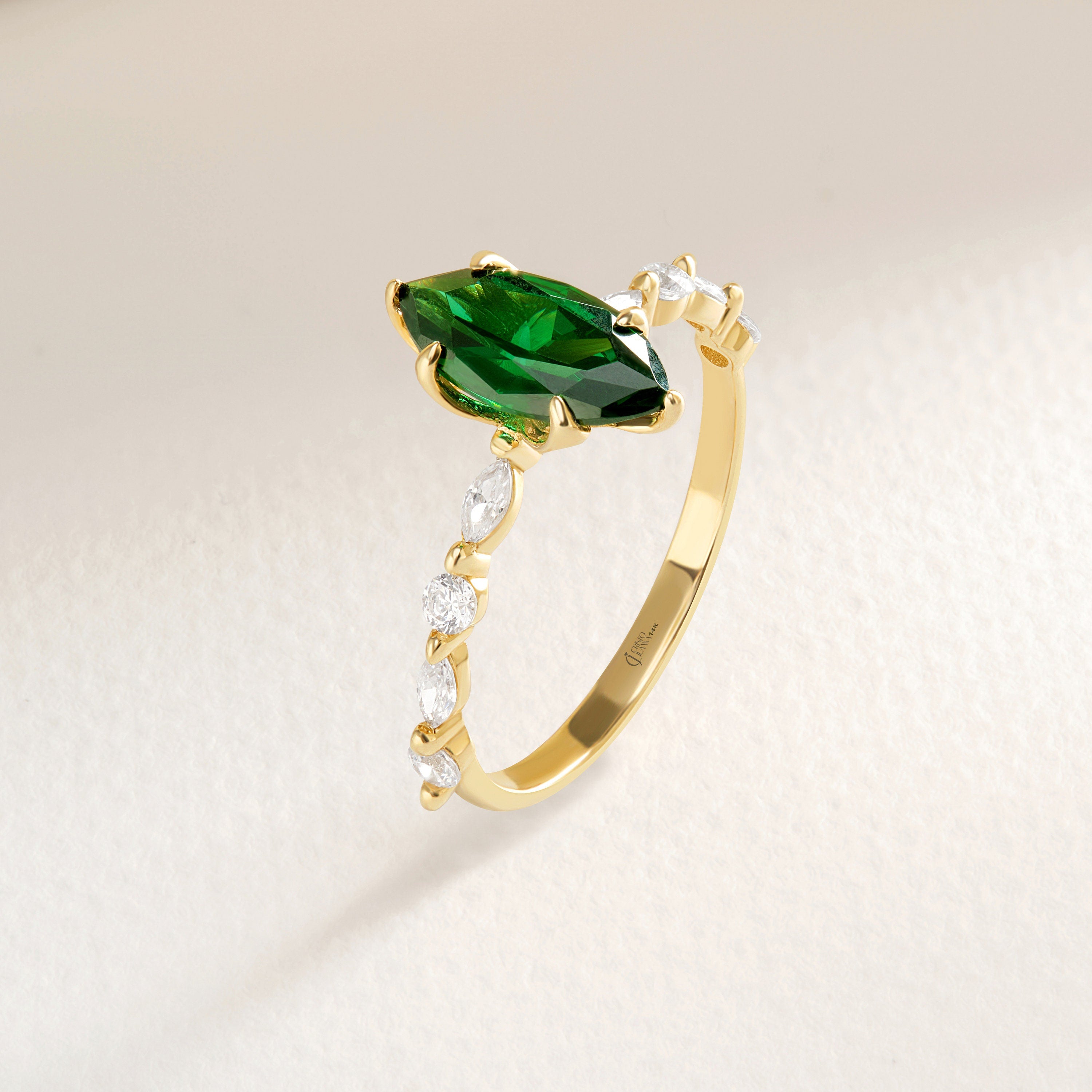 💚 Marquise Emerald Engagement Ring – 14K Solid Gold Side Diamond Band 💍

Make her heart sparkle with this marquise-cut emerald engagement ring, featuring a vivid green gemstone at its center and dazzling round-cut side diamonds for extra brilliance. This piece combines timeless elegance with a touch of modern artistry — perfect for engagements, anniversaries, or meaningful gifts.