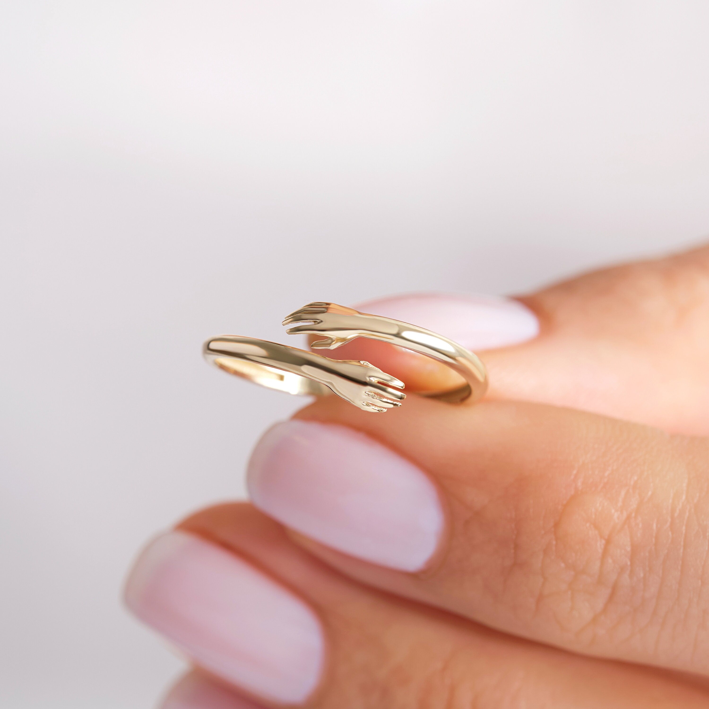 Here's the Hugging Lovingly Ring Gold by Christo! Our 10K 14K 14K Gold Hug Stacking Ring is perfect Stackable and Daily Wear Ring for Girls. This Love Hands Open Cuff Stacked Band is designed as Premium Chick Index Finger Ring