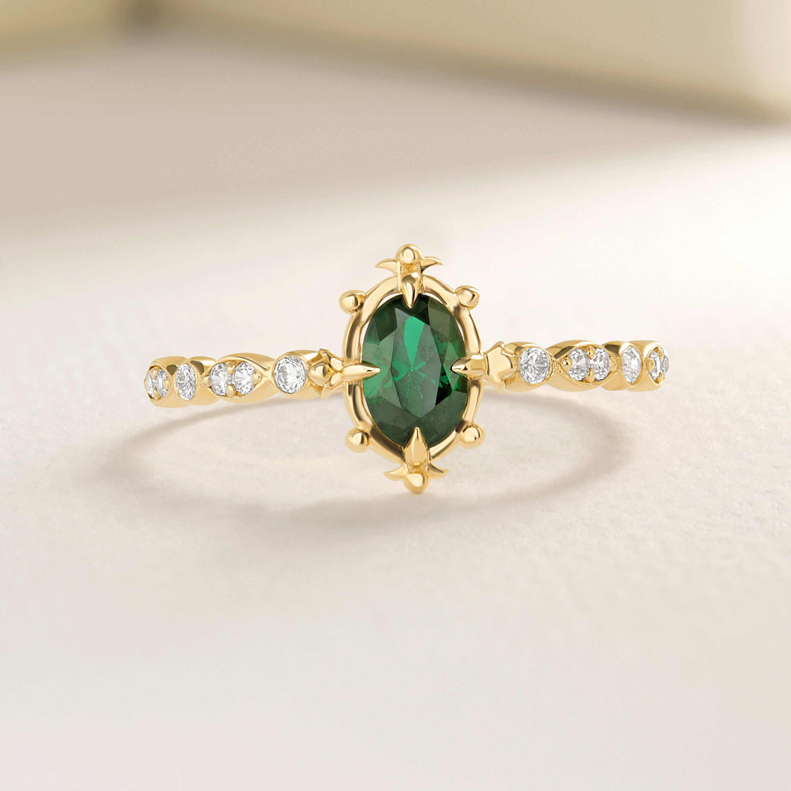 Oval Emerald Art Deco Wedding Ring – 10K / 14K / 18K Solid Gold 💚✨
A stunning oval-cut emerald set on a sleek art deco-inspired band, accented with sparkling round diamonds. Perfect as a birthstone, engagement, or wedding ring, this elegant design can also be customized with Diamond or Moissanite side stones.