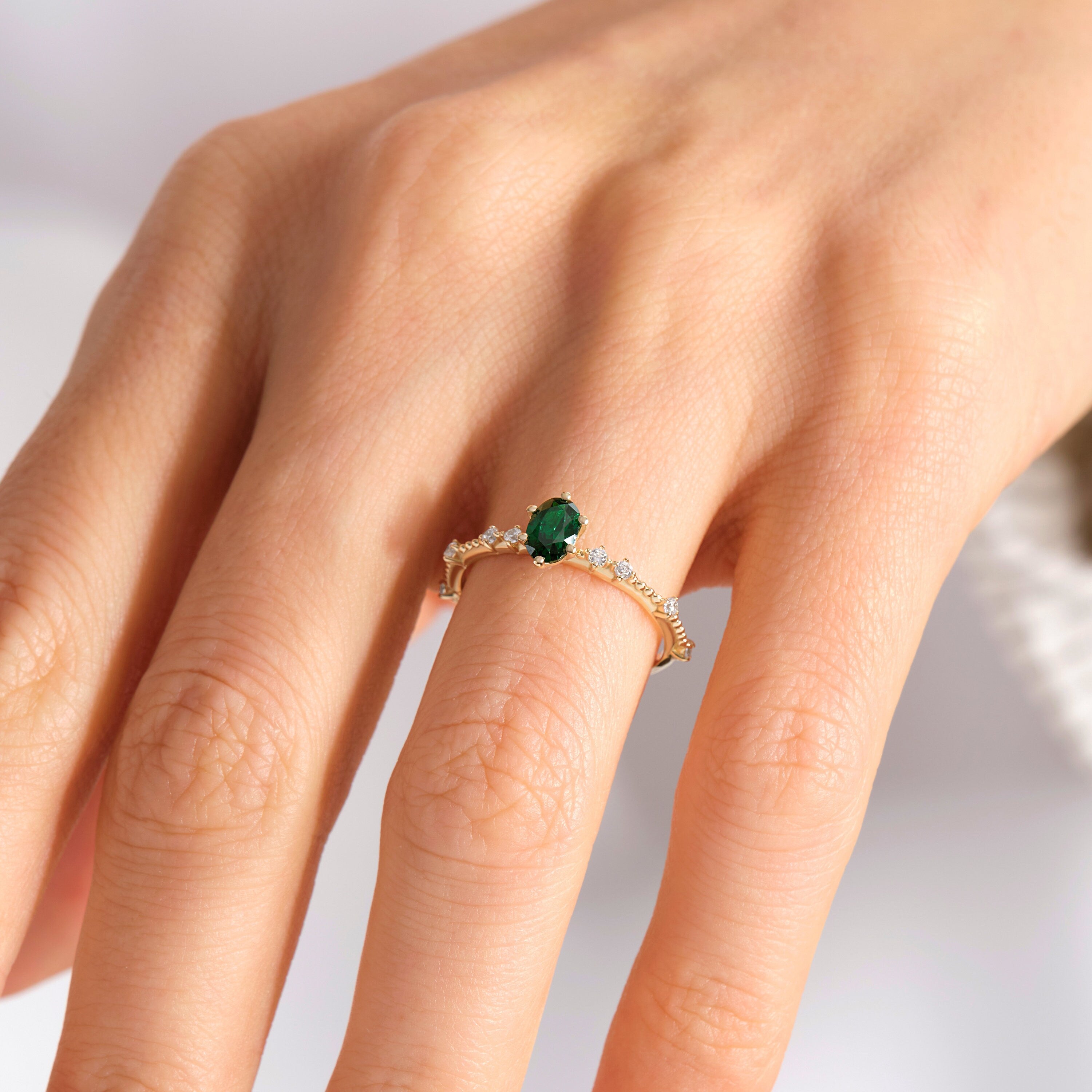 Oval Emerald Engagement Ring – 14K Solid Gold with Side Diamonds 💚✨
Elegant, timeless, and deeply symbolic — this oval emerald engagement ring celebrates love and renewal in every detail. Featuring a vivid green oval-cut emerald at its center, delicately framed by a fine row of tiny moissanite diamonds, this piece perfectly balances luxury and sentiment. Its milgrain side detailing adds a subtle vintage touch, making it an ideal ring for weddings, anniversaries, or heartfelt gifts.