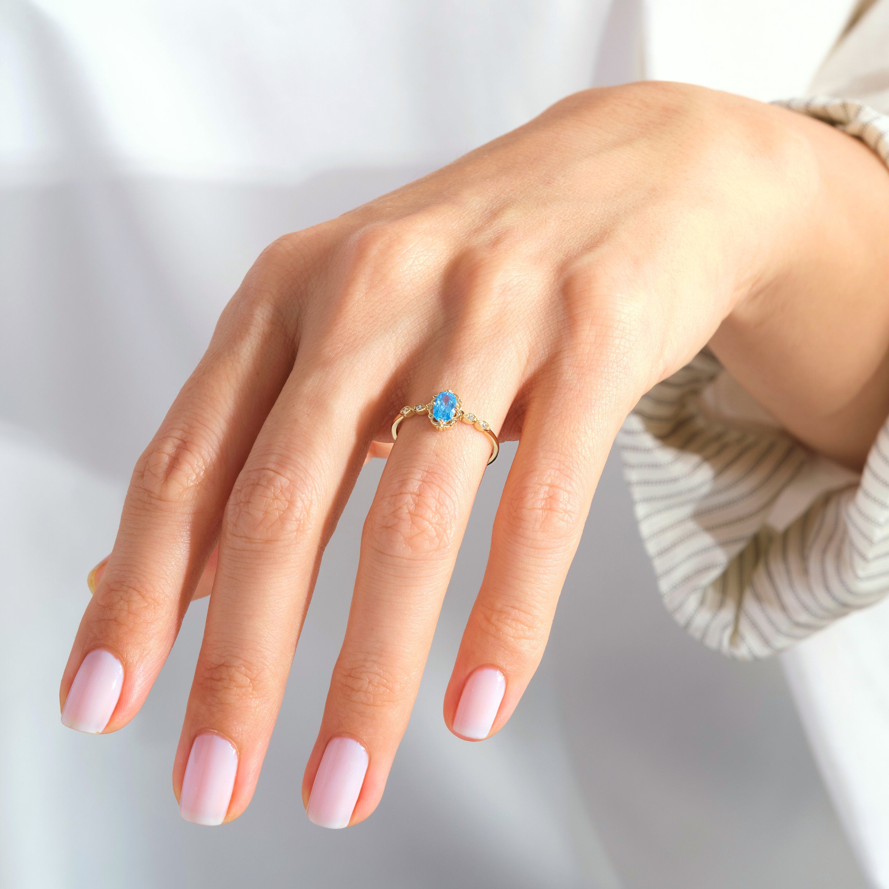 Oval Blue Topaz Engagement Ring – 14K Solid Gold Lace Band 💙✨
Delicate, radiant, and full of charm — this Oval Blue Topaz Engagement Ring brings a touch of the sky to your hand. Expertly crafted in solid 14K gold, it features a 6x4 mm oval-cut blue topaz, symbolizing peace and loyalty, surrounded by sparkling moissanites or diamonds on a graceful lace-inspired band.