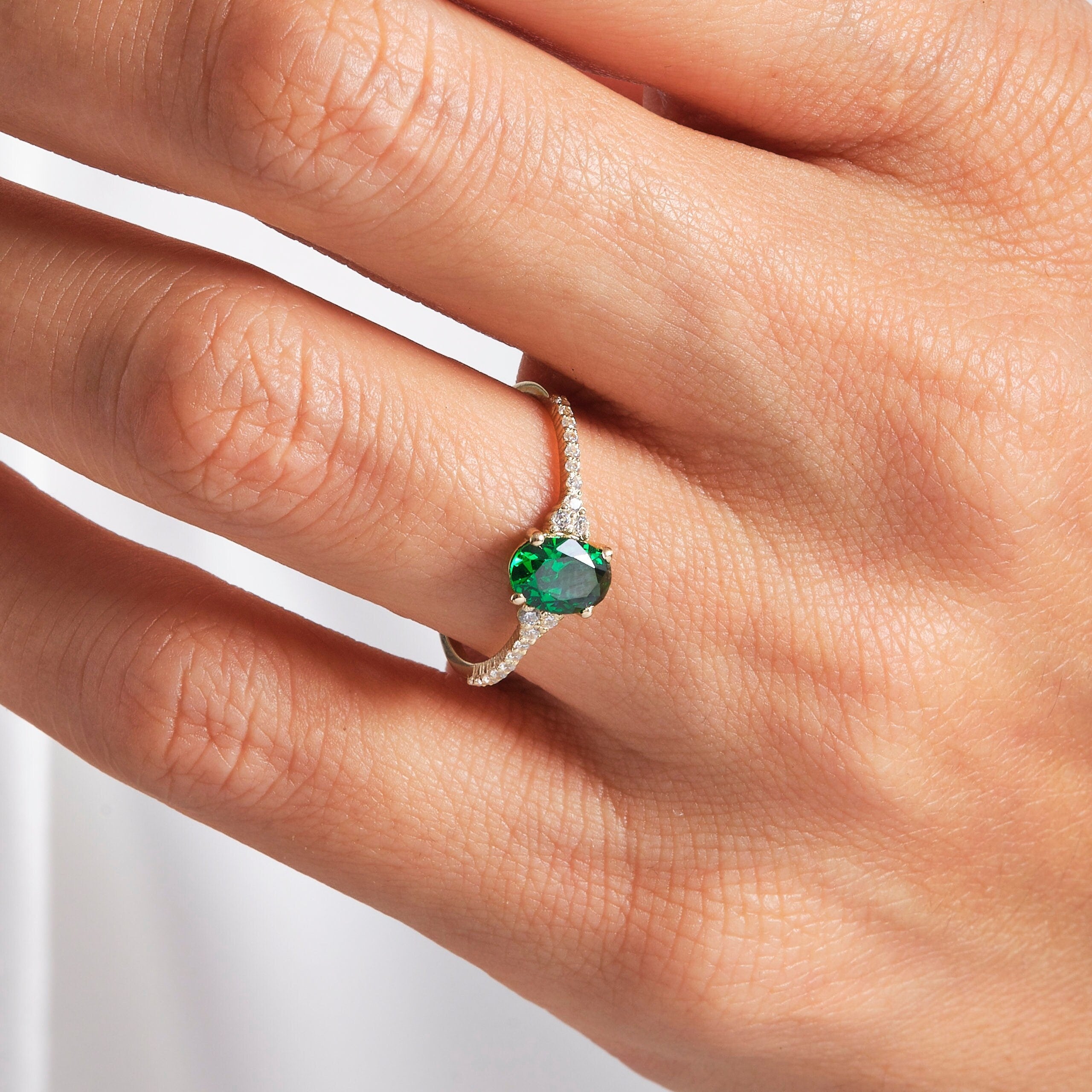 Oval Emerald Engagement Ring – 14K Solid Gold with Side Diamonds 💚✨
Refined, radiant, and meaningful — this Oval Emerald Engagement Ring brings together timeless elegance and modern sparkle. The deep green emerald at its center symbolizes love and renewal, while the shimmering side moissanites add a touch of brilliance for a truly captivating finish.