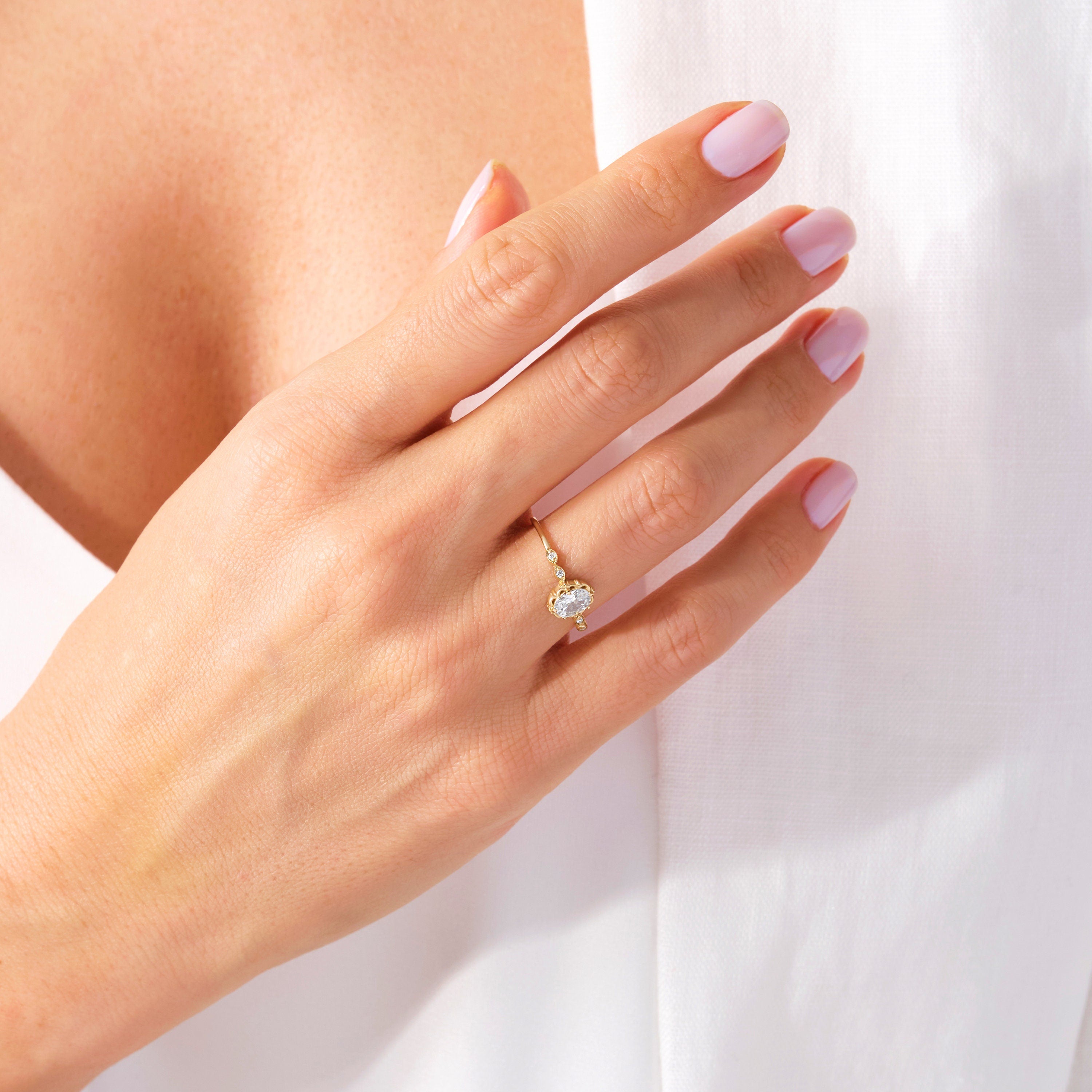 💍 Oval Diamond Engagement Ring — 14K Solid Gold Moissanite Wedding Band

This elegant oval engagement ring features a sparkling center stone paired with a delicate row of tiny accent gems. Its slim solid-gold band and refined silhouette make it perfect as a proposal ring, wedding band, promise ring, or everyday luxury piece. A timeless design for women who love delicate, feminine fine jewelry.