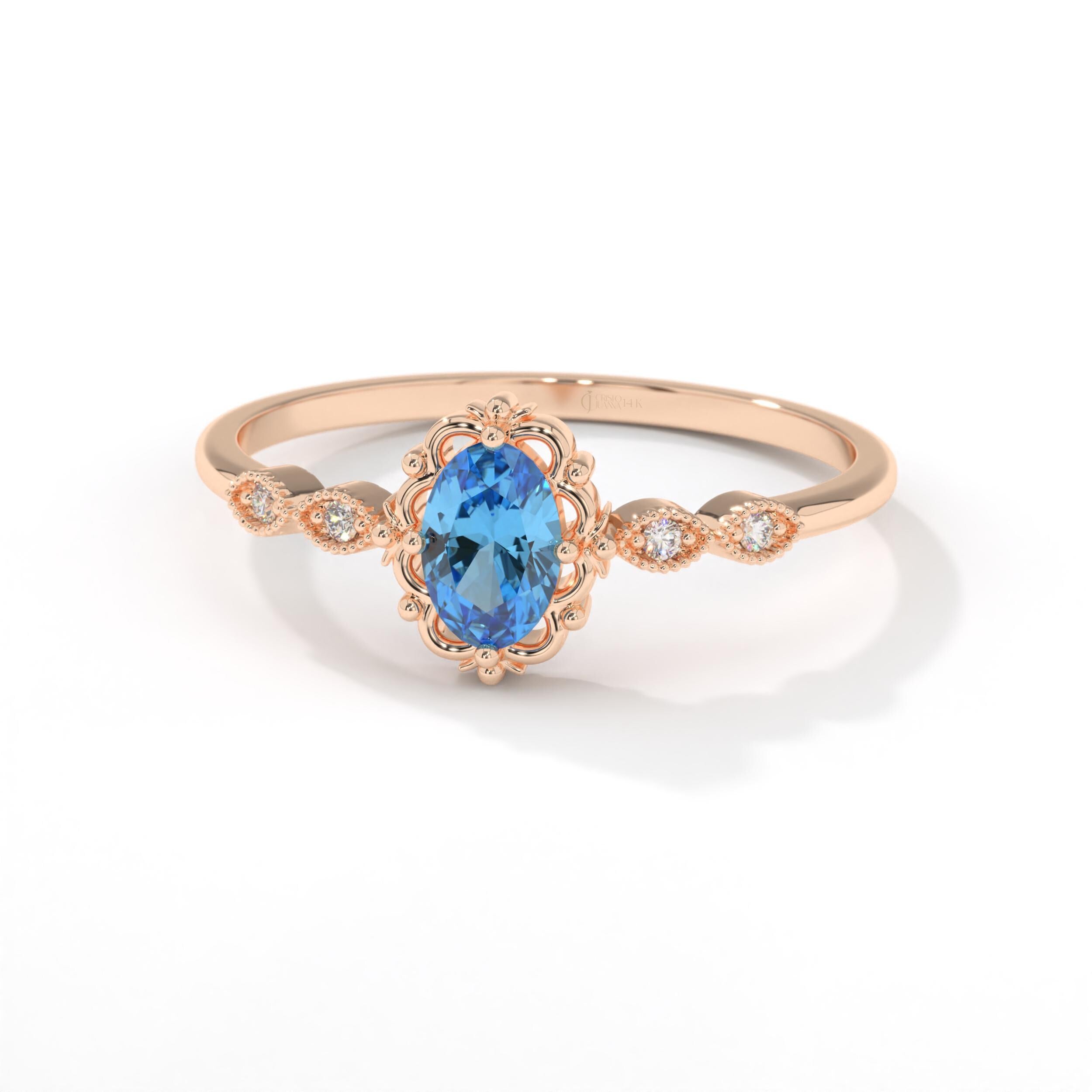 Oval Blue Topaz Engagement Ring – 14K Solid Gold Lace Band 💙✨
Delicate, radiant, and full of charm — this Oval Blue Topaz Engagement Ring brings a touch of the sky to your hand. Expertly crafted in solid 14K gold, it features a 6x4 mm oval-cut blue topaz, symbolizing peace and loyalty, surrounded by sparkling moissanites or diamonds on a graceful lace-inspired band.