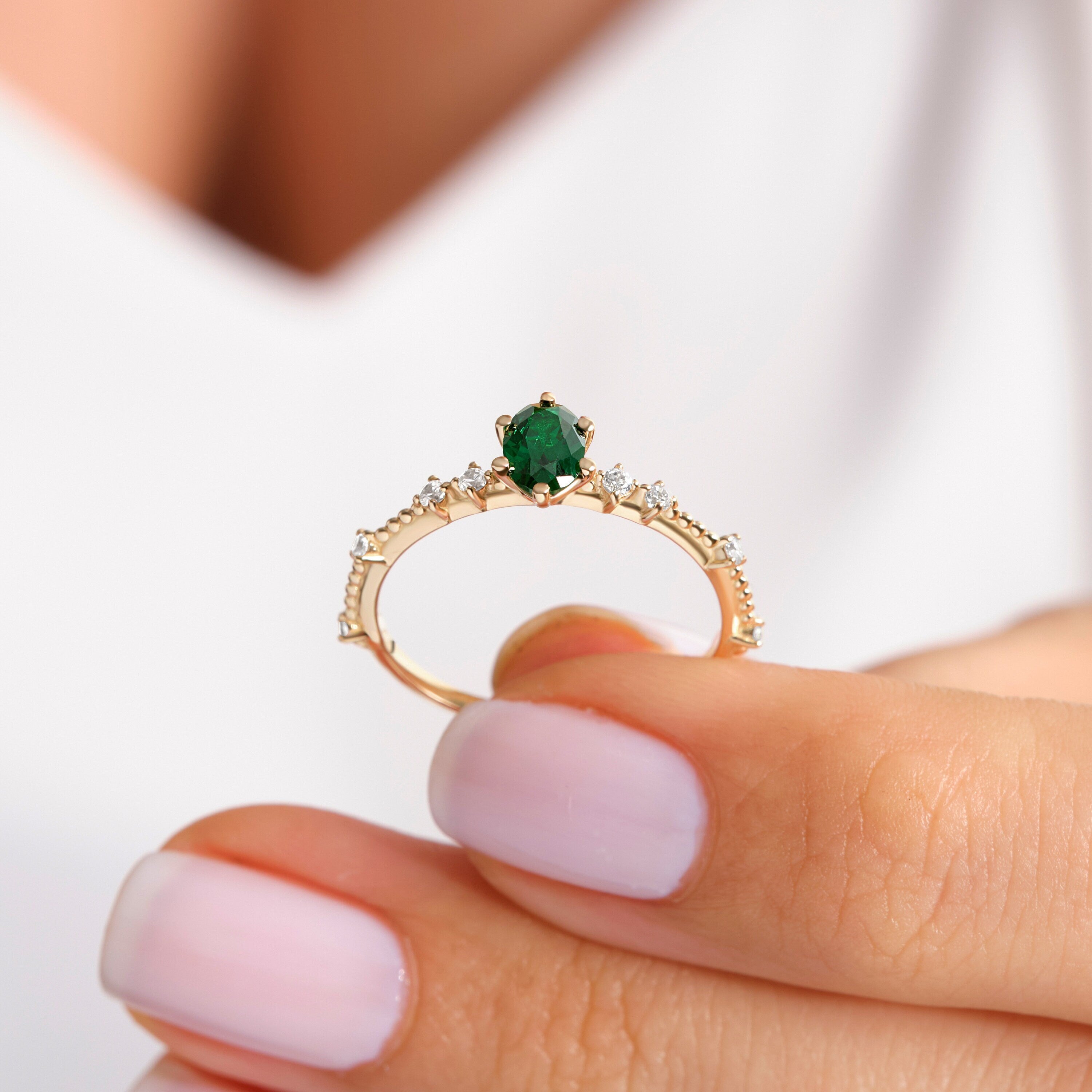 Oval Emerald Engagement Ring – 14K Solid Gold with Side Diamonds 💚✨
Elegant, timeless, and deeply symbolic — this oval emerald engagement ring celebrates love and renewal in every detail. Featuring a vivid green oval-cut emerald at its center, delicately framed by a fine row of tiny moissanite diamonds, this piece perfectly balances luxury and sentiment. Its milgrain side detailing adds a subtle vintage touch, making it an ideal ring for weddings, anniversaries, or heartfelt gifts.