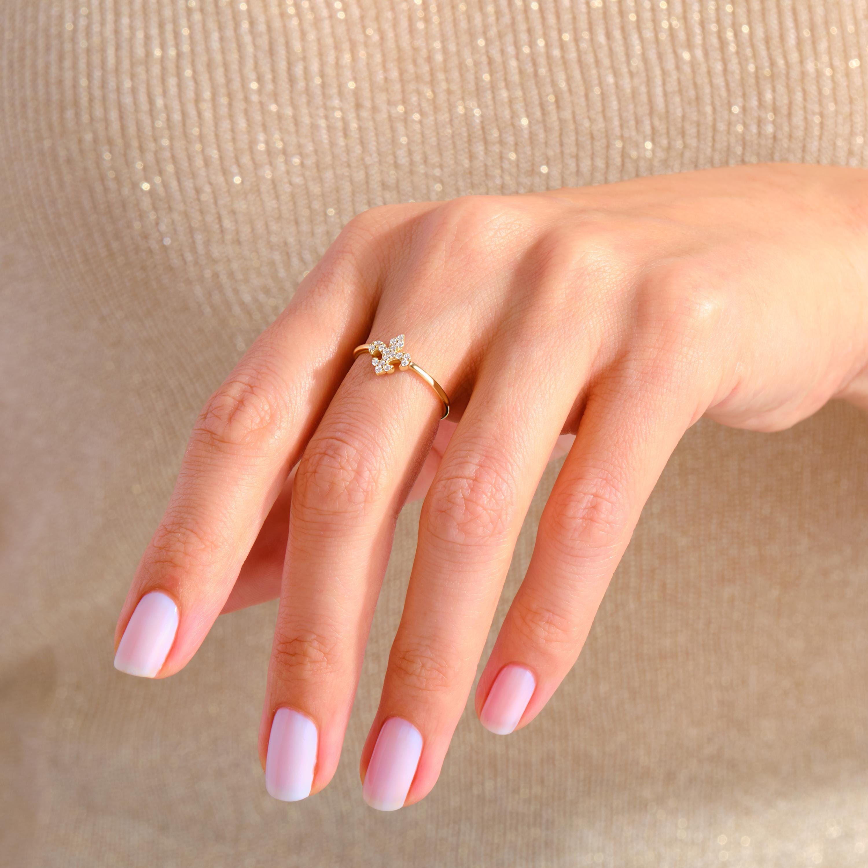 Fleur De Lis Diamond Ring – 14K Gold Stackable Lotus Symbol Ring for Women 💎🌸
A delicate blend of symbolism and sparkle, this Fleur De Lis ring features micro pave moissanite stones set in solid 14K gold. Representing purity, strength, and elegance, this lotus-inspired band is a meaningful and stylish choice for stacking or solo wear.