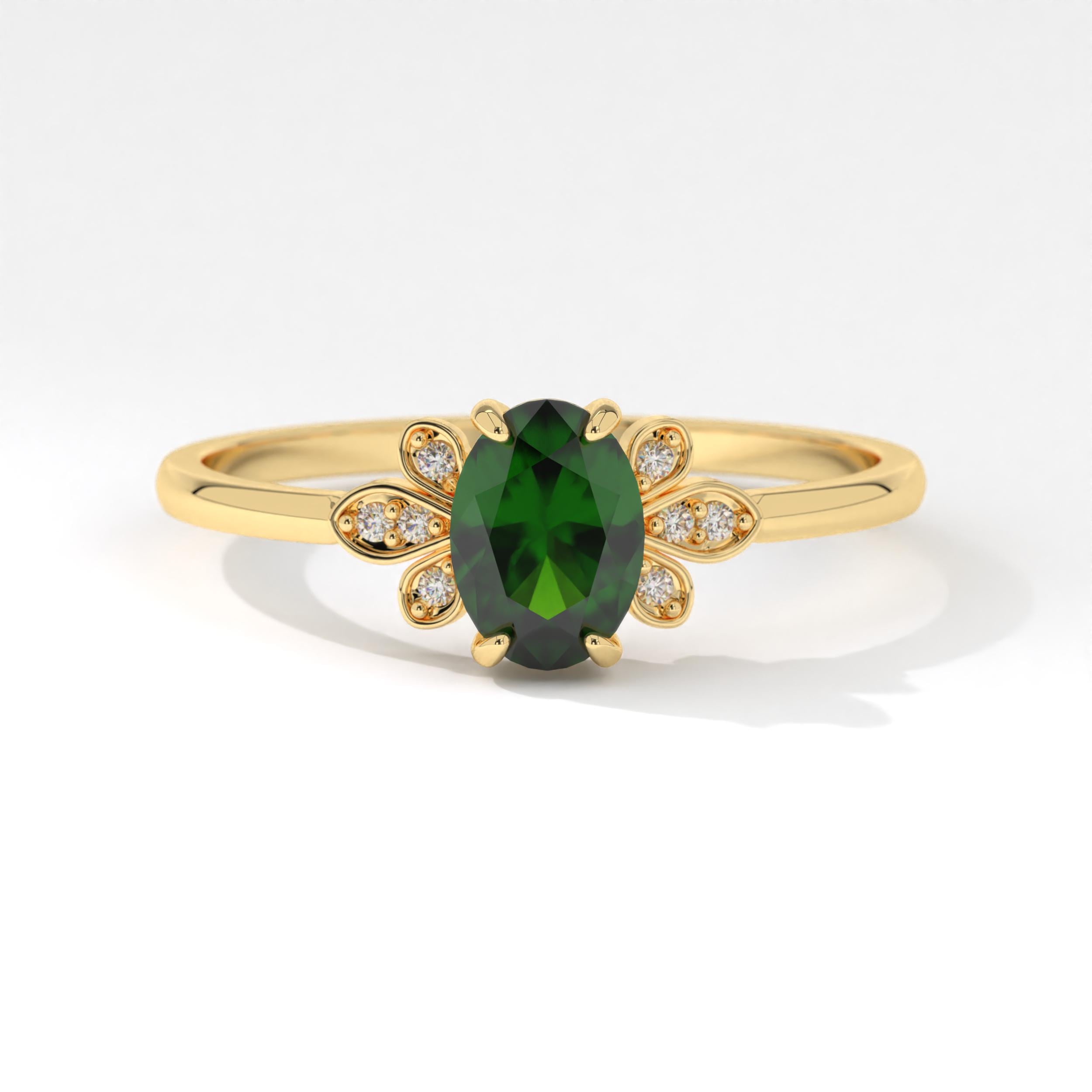 May include: A gold ring features an oval-shaped, dark green gemstone encircled by a floral design of small, sparkling diamonds. The ring's band is thin and delicate, complementing the elegant gemstone and diamond accents. This exquisite piece showcases a sophisticated and timeless style, perfect for adding a touch of elegance to any occasion. The rich green hue of the gemstone contrasts beautifully with the bright gold band and the clear diamonds, creating a visually stunning piece of jewelry.
